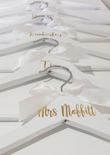 Load image into Gallery viewer, Bridal Party White Wooden Coat Hangers with Gold Names and White Bow
